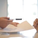 Vertragsunterlagen und Autoschlüssel auf einem Tisch während eines Finanzierungsgesprächs