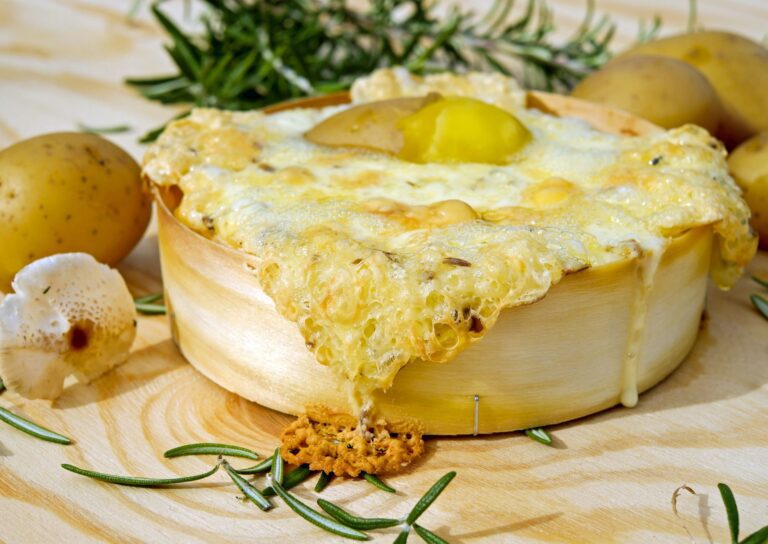 Geschmolzener Raclettekäse wird über Kartoffeln geschabt