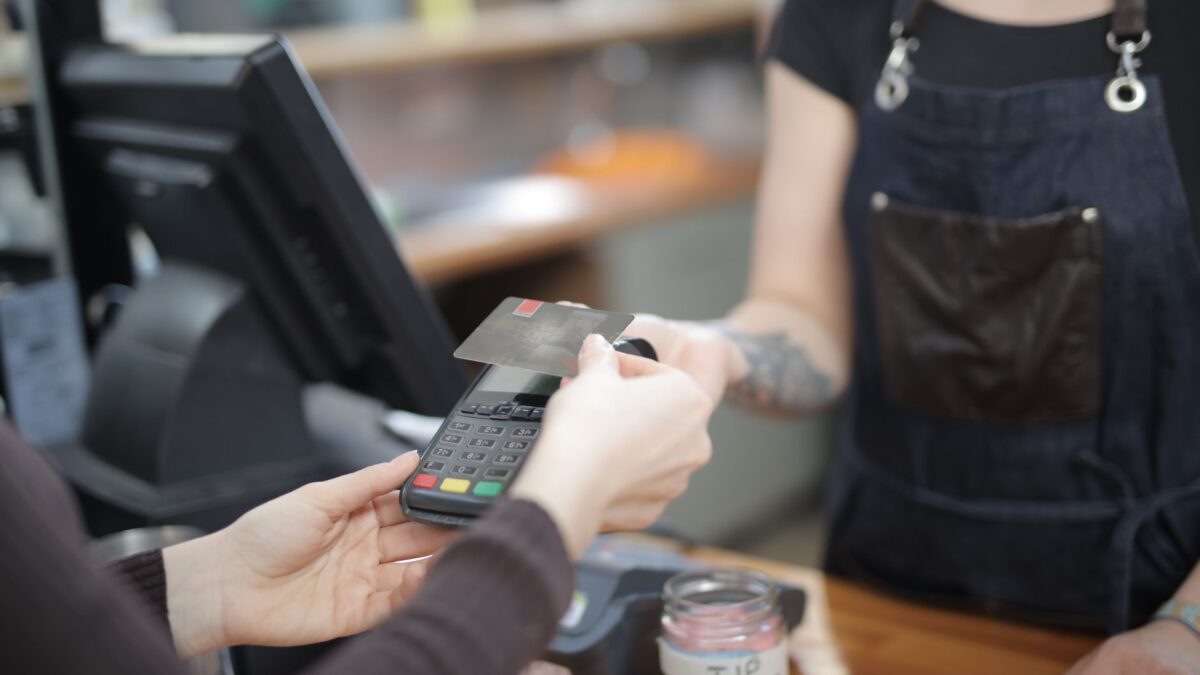 Gast bezahlt im Restaurant kontaktlos mit der Karte am Terminal