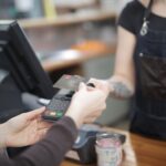 Gast bezahlt im Restaurant kontaktlos mit der Karte am Terminal