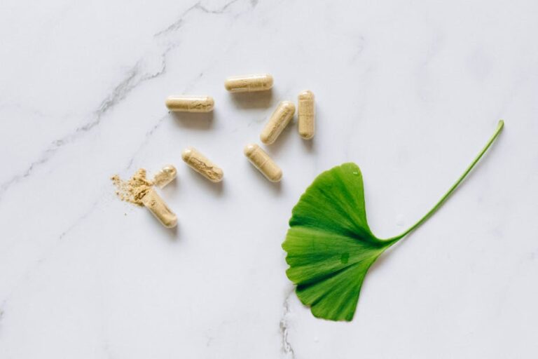 tisso - Top view of Ginkgo Biloba capsules with a leaf on a marble surface, symbolizing natural supp
